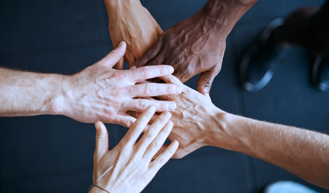 Personas diversas uniendo sus manos