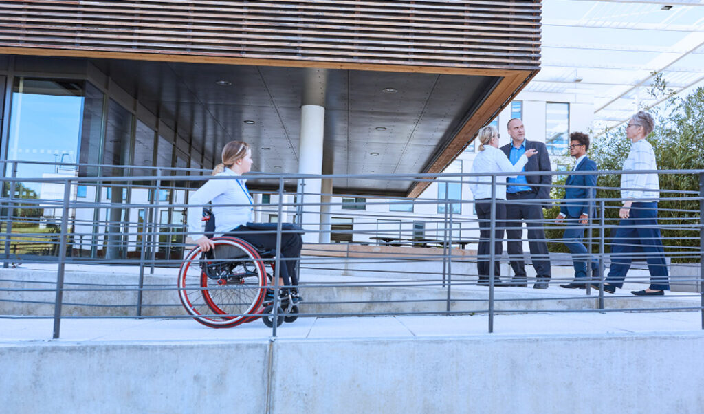 Mujer usuaria de silla de ruedas subiendo por una rampa