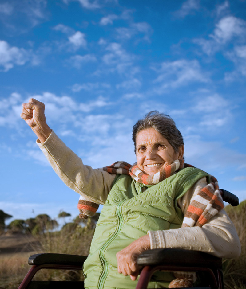 Mujer mayor rural sonriendo y levantado el puño