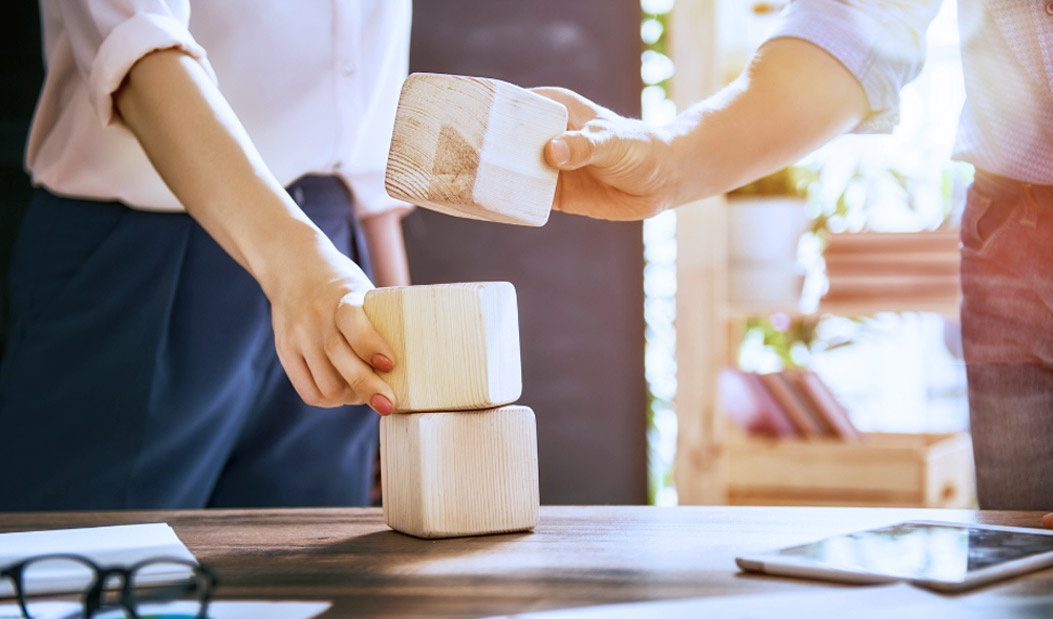 Dos personas construyendo con objetos de madera