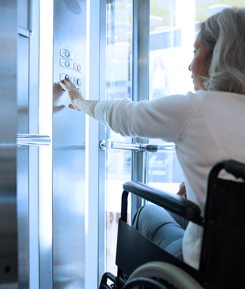 Mujer en silla de ruedas llamando al ascensor